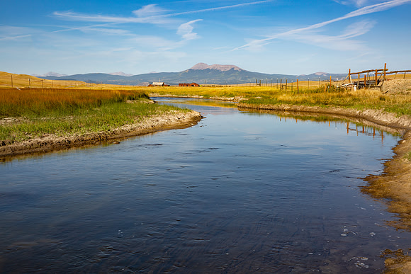 19.7 MB, 5760 x 3840: Meandering slow moving stream flows towards the mountains