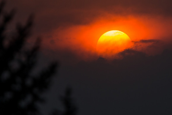 1.45 MB, 2527 x 1685: The large bright orange sun setting between storm clouds near Colorado Springs, Colorado.