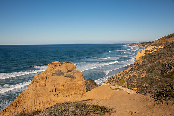 27.9 MB, 6720 x 4480: From a cliff top the shore line stretches for miles as the white waves come into the beach.