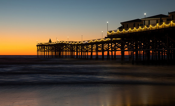 13.0 MB, 6720 x 4066: Christmas lights on Chrystal Pier shine at sunset.